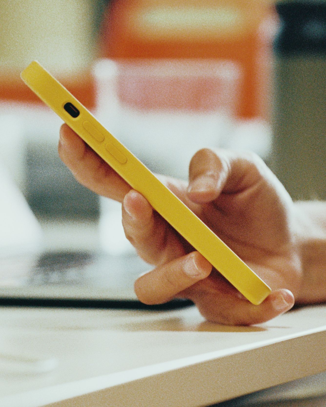 Closeup of a hand holding a yellow phone