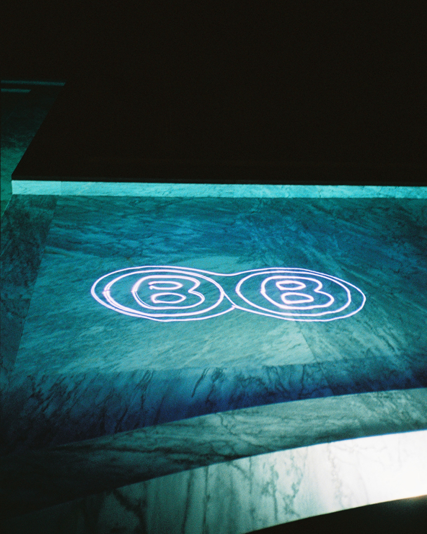 A pool a night, a laser reflects a company logo with two BB letters