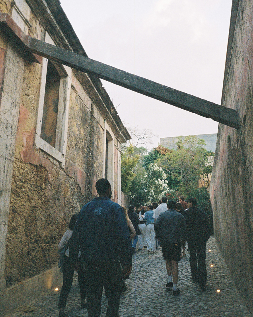 A group walking in a narrow, pedestrian street. Old buildings.