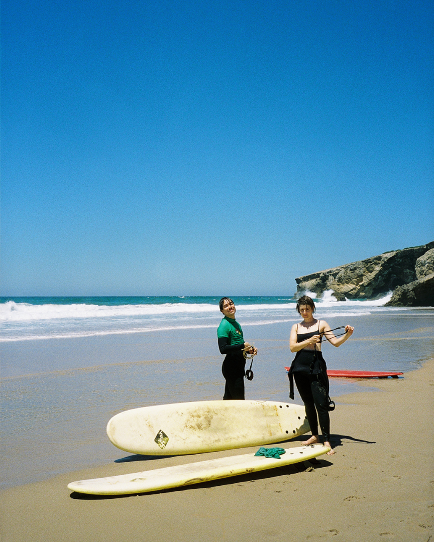Two people standing at the beach with two surf boards